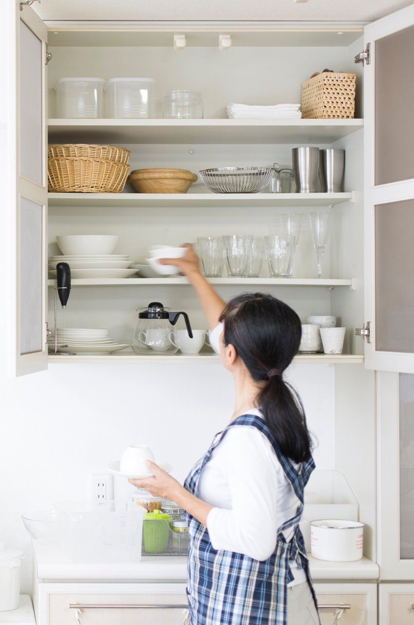 A woman organizing the kitchen shelf