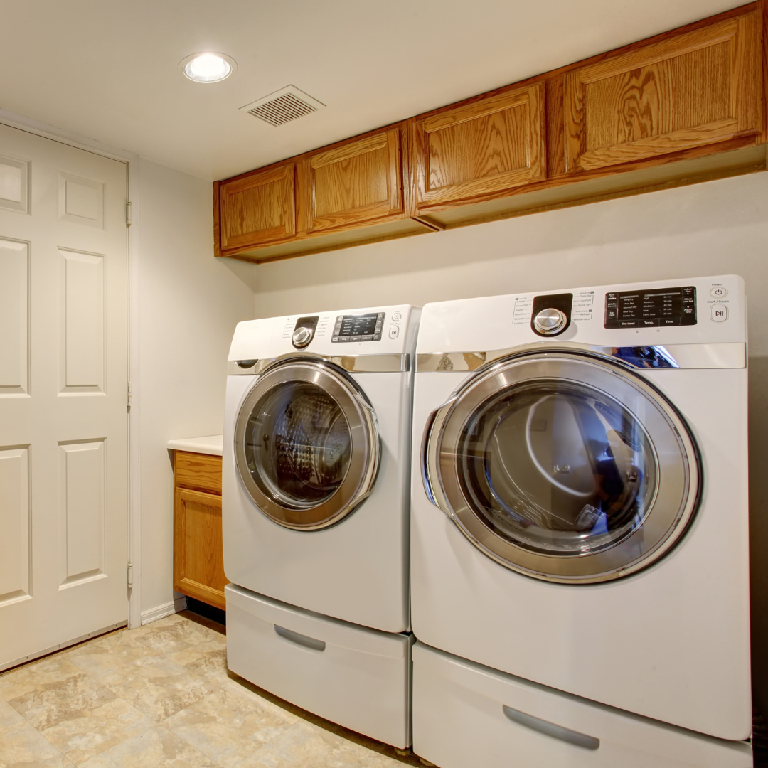 A laundry room with two washers and two dryers