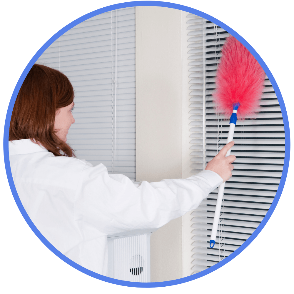 woman dusting window blinds