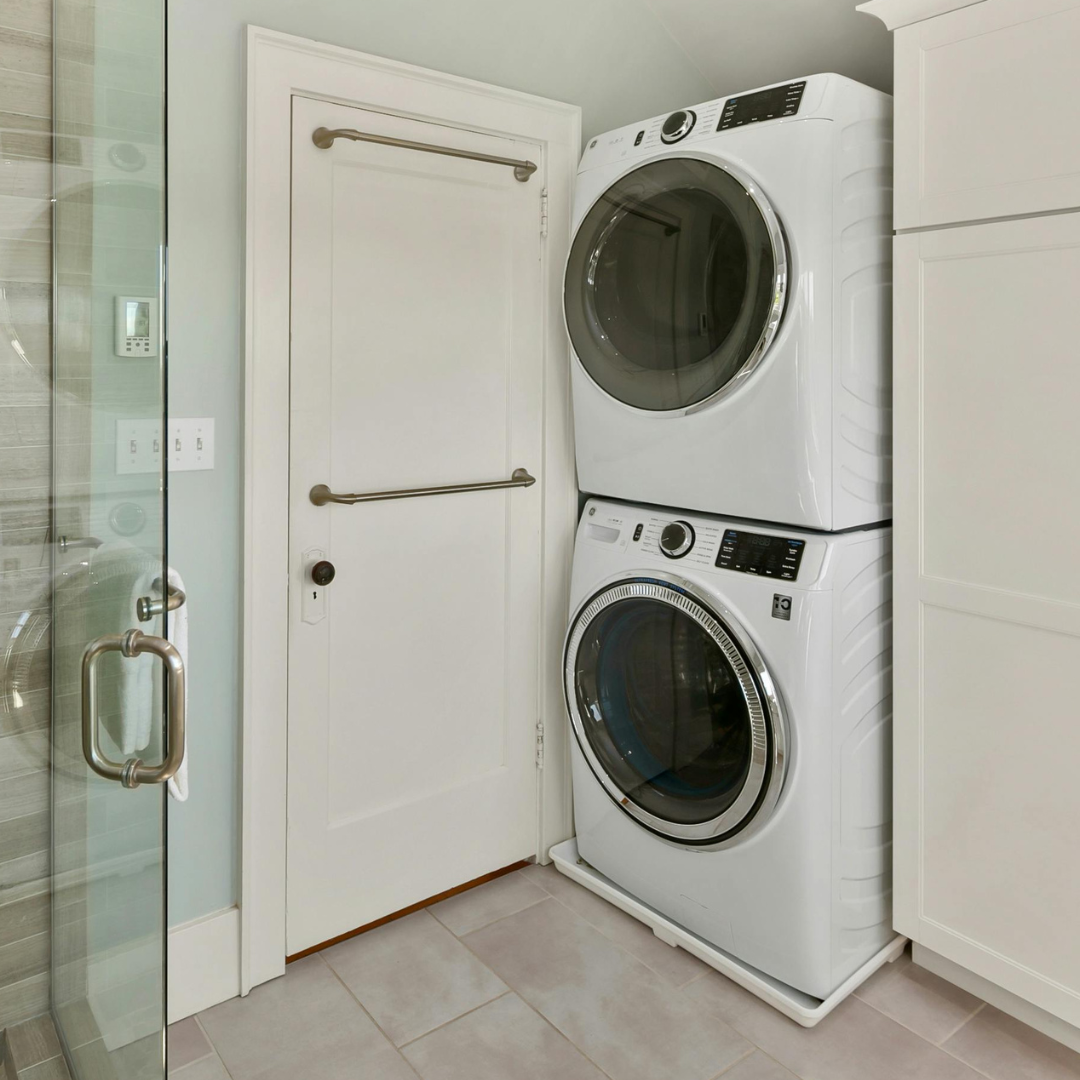 A washer and dryer are stacked on top of each other in a laundry room