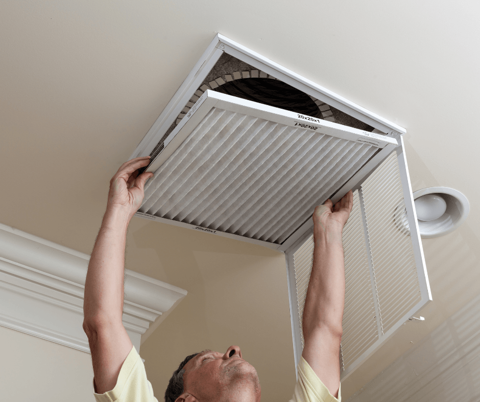 Man opening up ceiling air duct vent