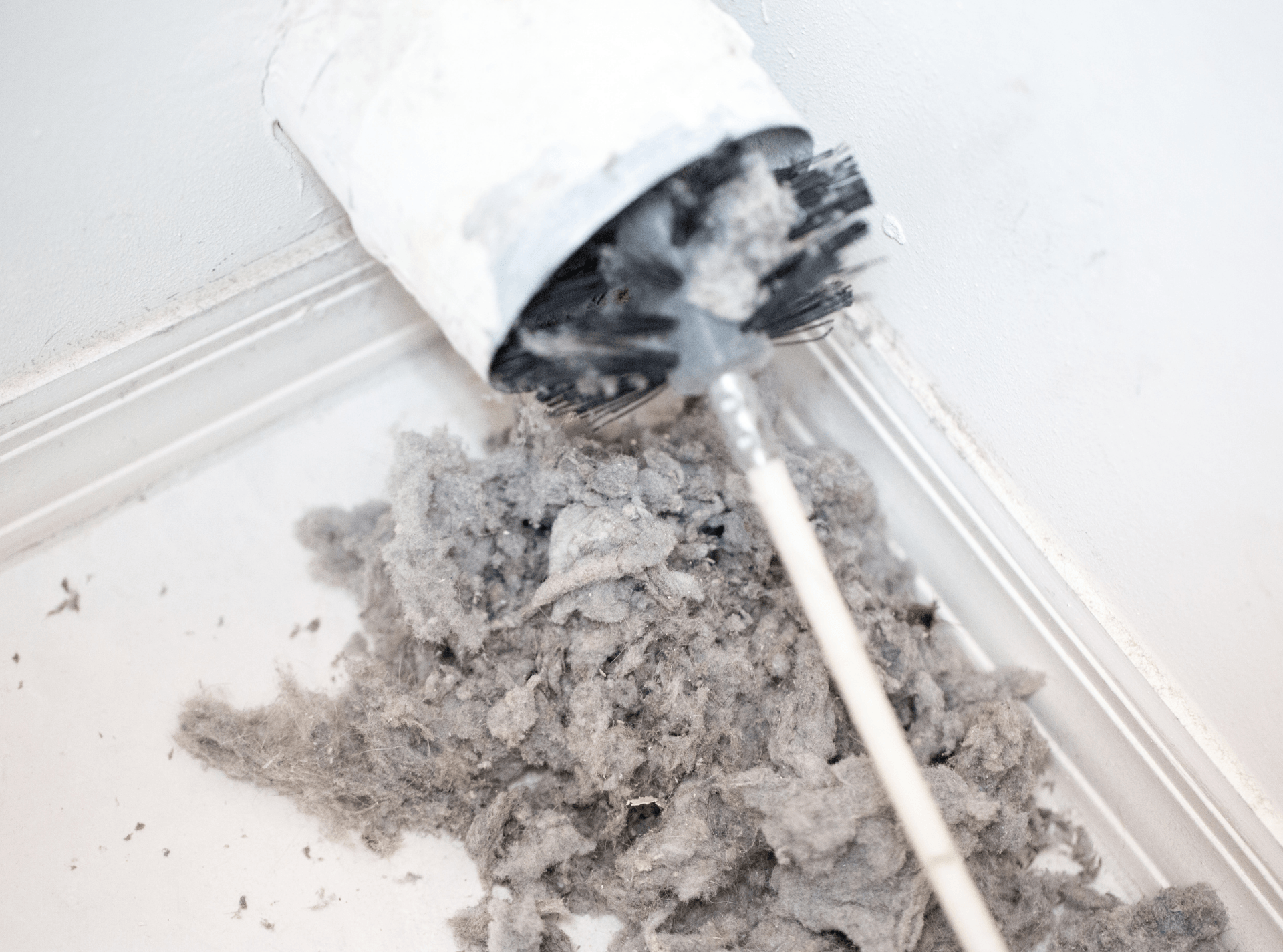 removing lint from dryer vent with a brush