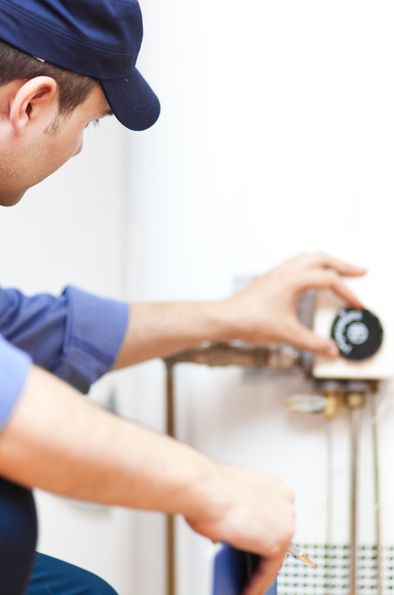 a man with a blue cap checking the water heater