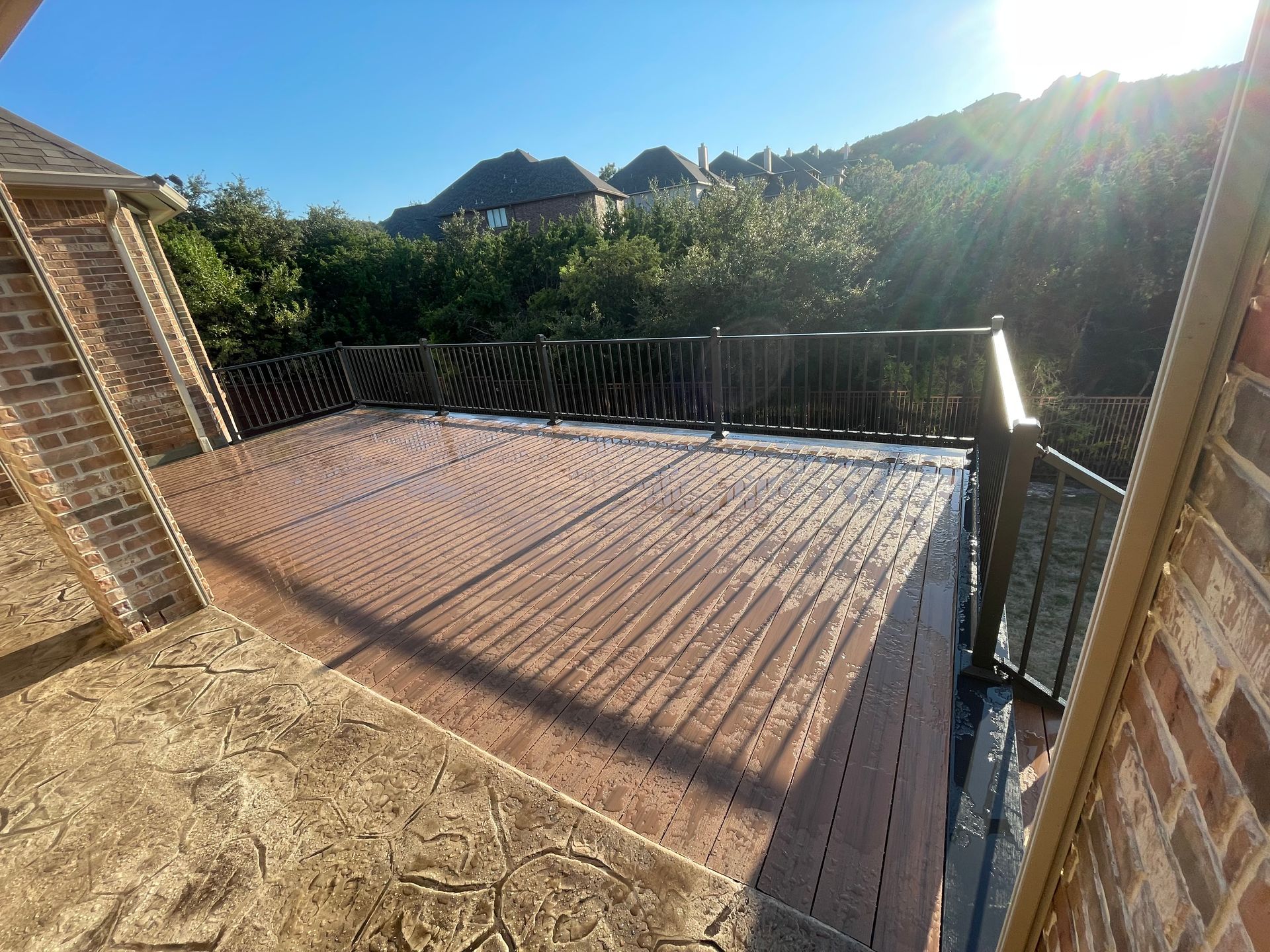 A brick building with a wooden deck and a metal railing.