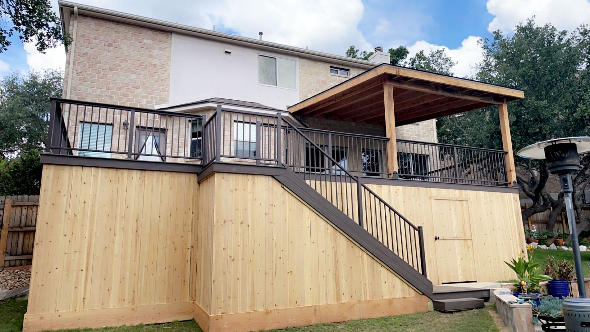 A house with a wooden deck and stairs leading up to it.