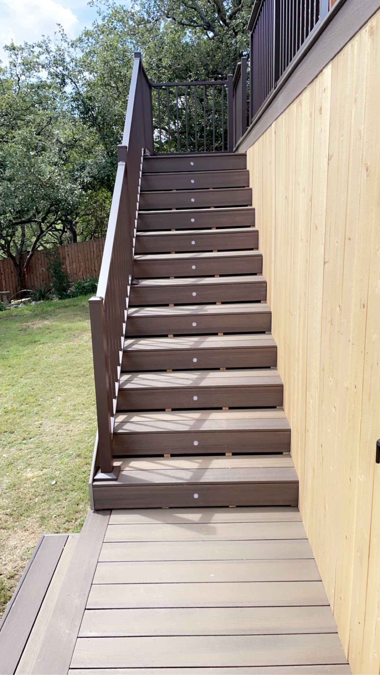 LED lit stairs on a wooden deck with metal rails