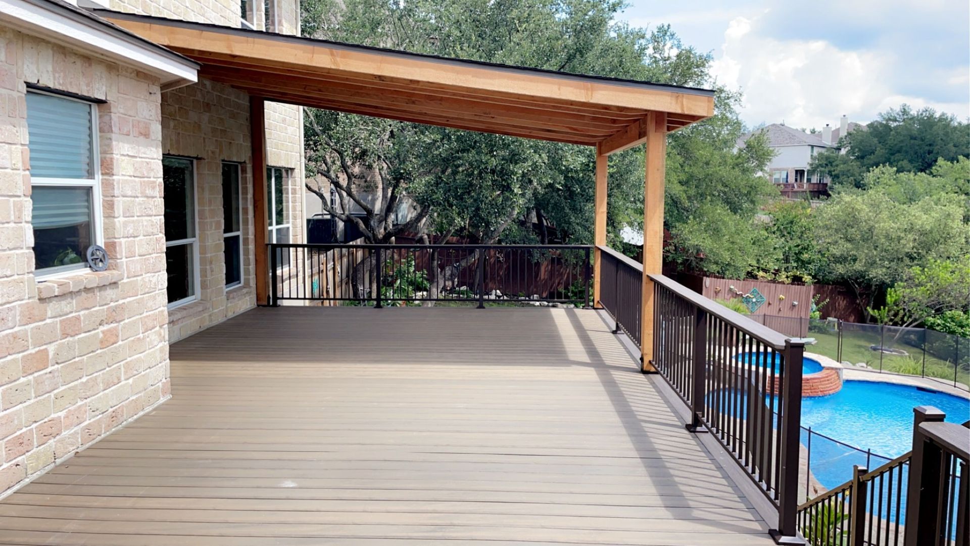 composite deck with custom roof cover leading to swimming pool