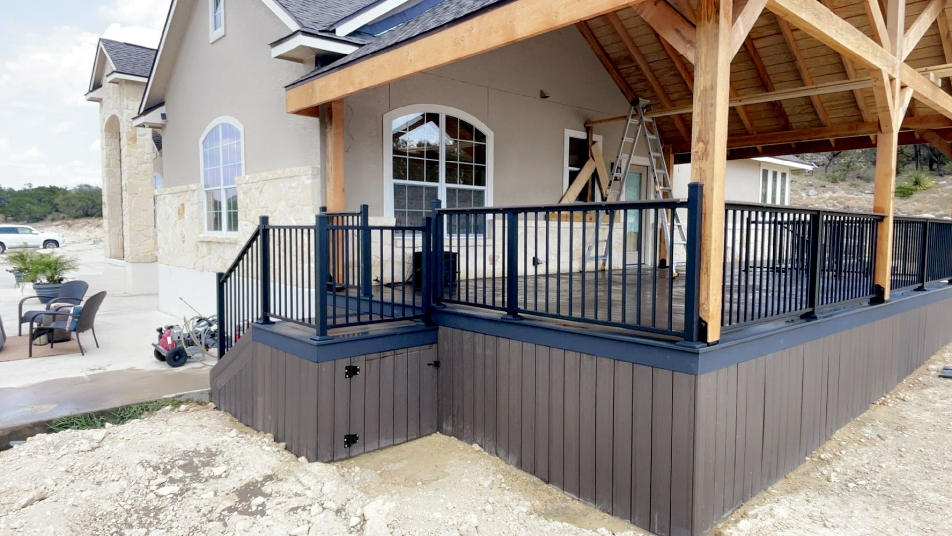 dark two-tone composite deck with roof cover on stone house