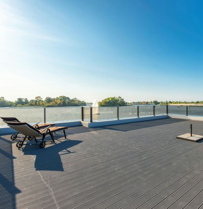 composite deck by lake with glass railing