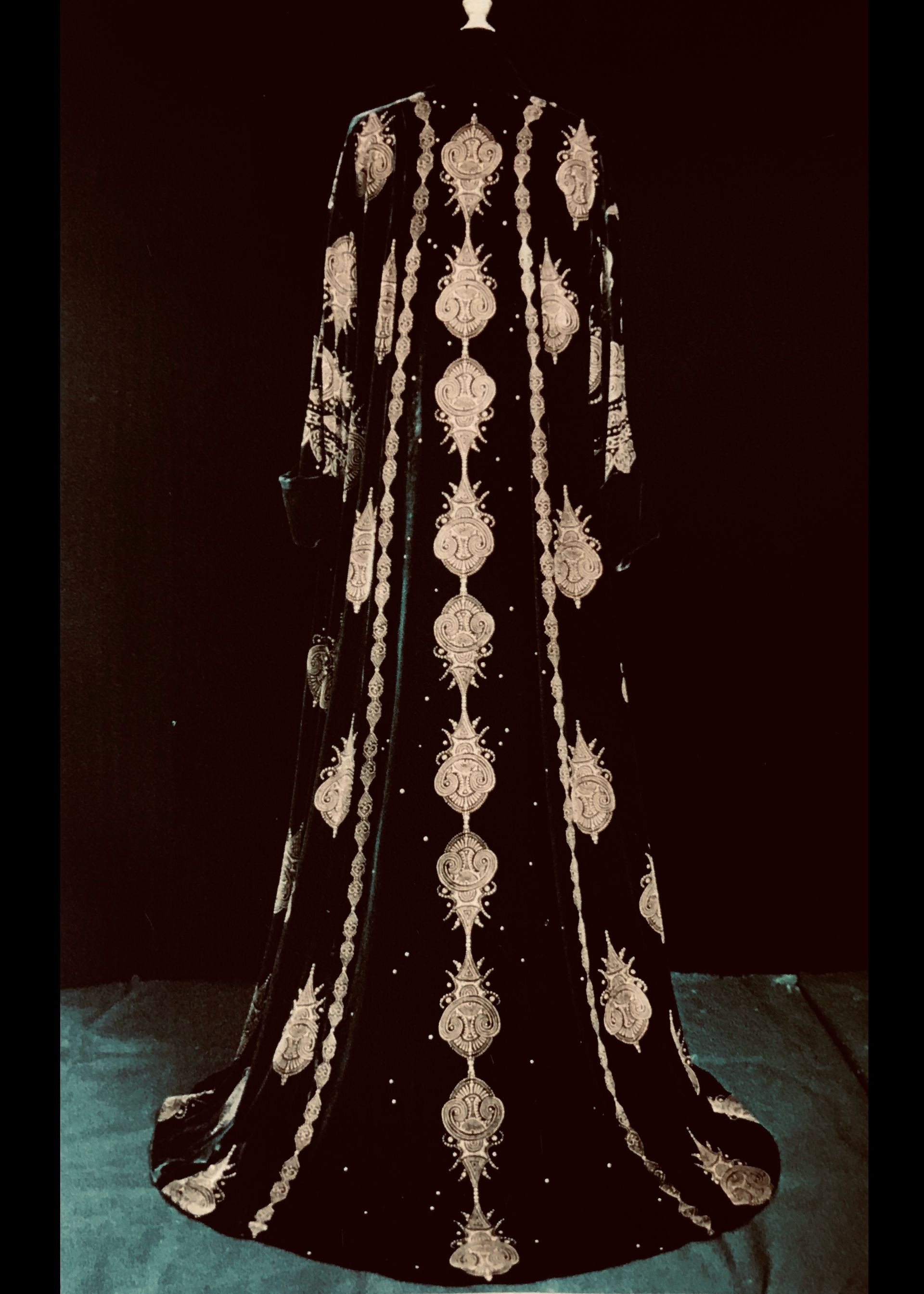 Black floor-length embroidered gown with white accents, displayed on a mannequin.