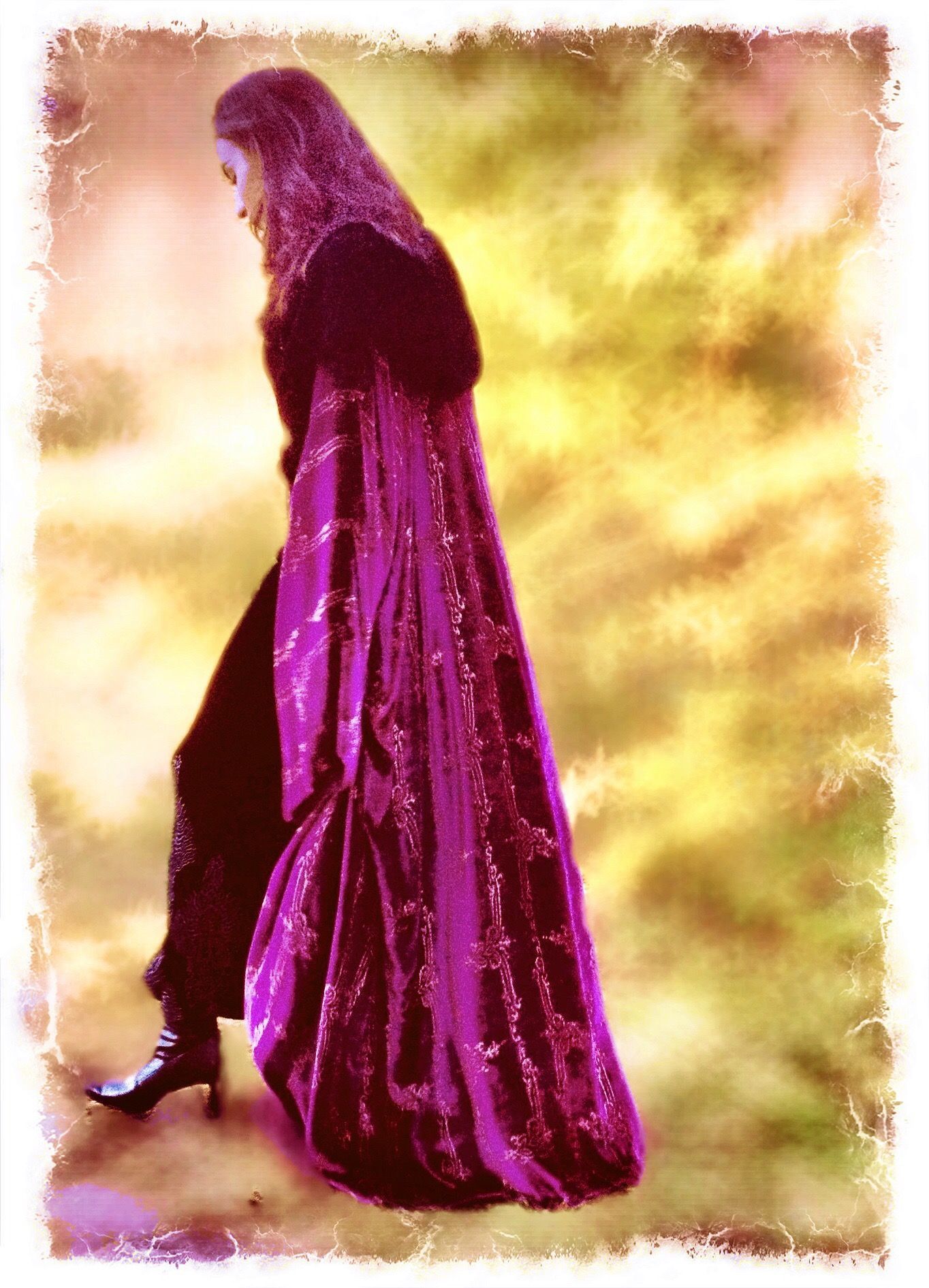 Person in black outfit and purple sequin cloak walking against a yellow and gold background.