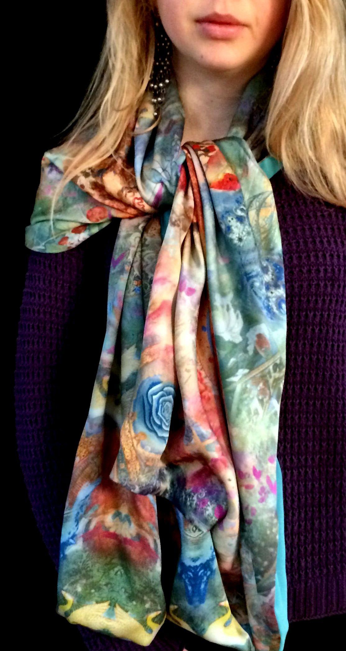 Woman wearing a colorful floral scarf tied around her neck, purple sweater.