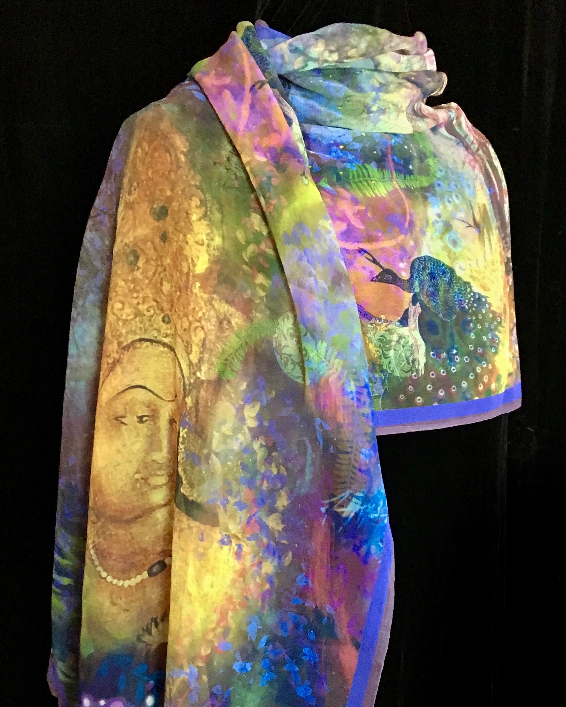 Silk scarf with colorful painted design featuring a face and bird on a black background.