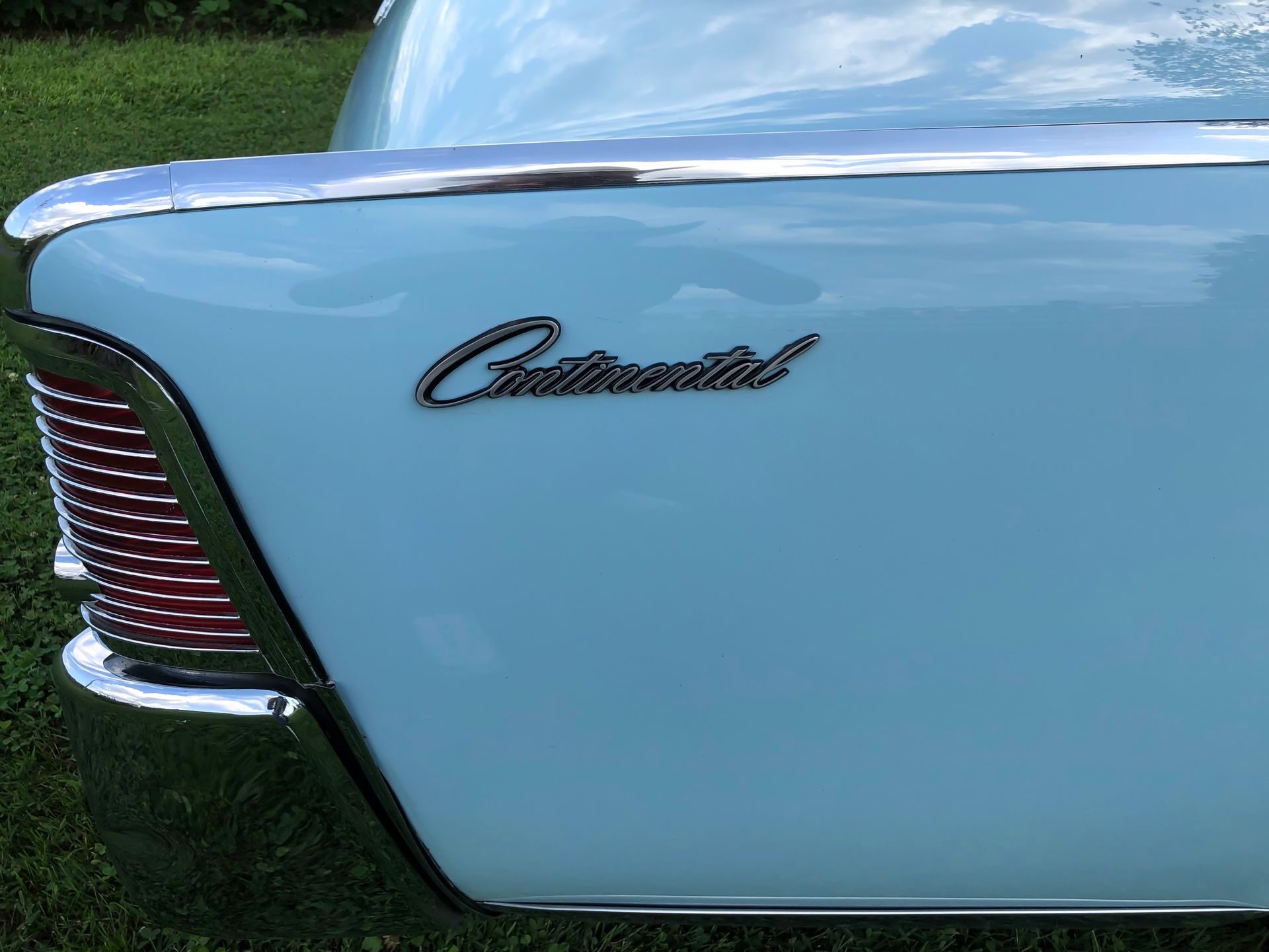 Light blue 1960s Lincoln Continental car rear with chrome trim and Continental script.