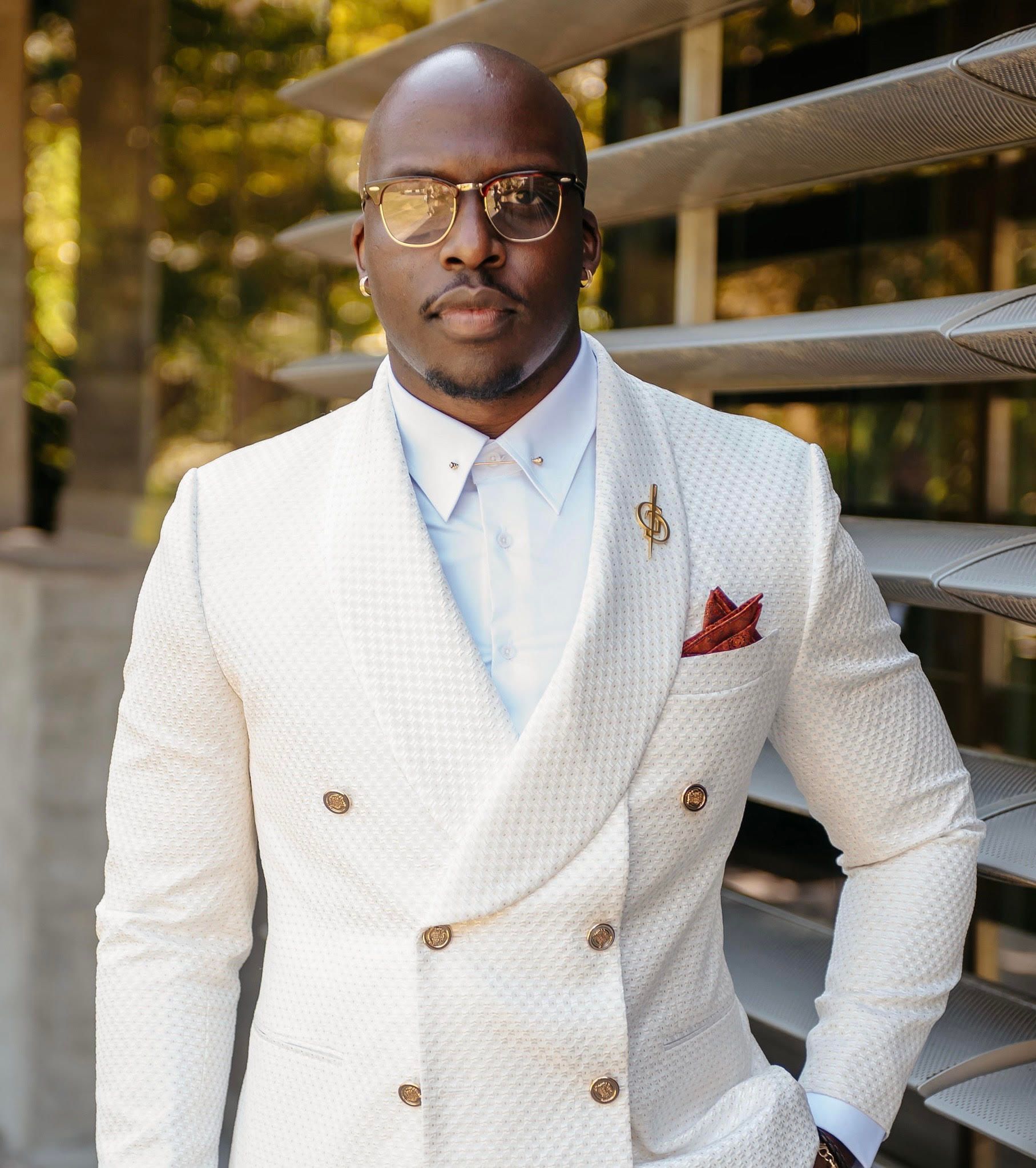 A man in a blue shirt and red tie smiles for the camera