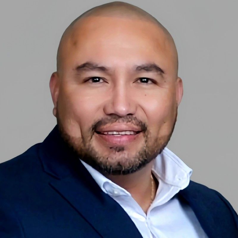 A man in a suit and tie is smiling for the camera.