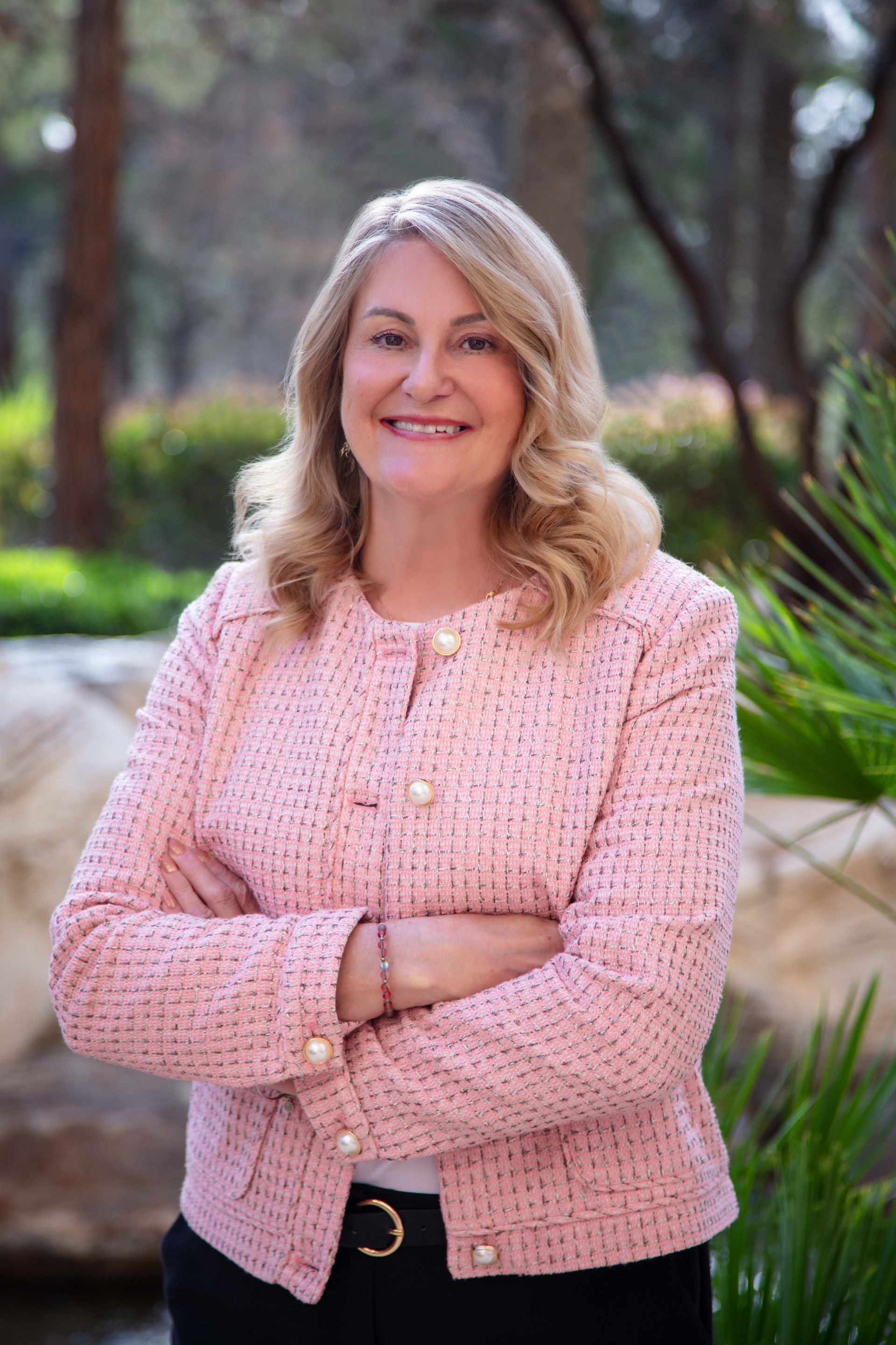 A woman wearing a blue jacket and a white shirt is smiling for the camera.