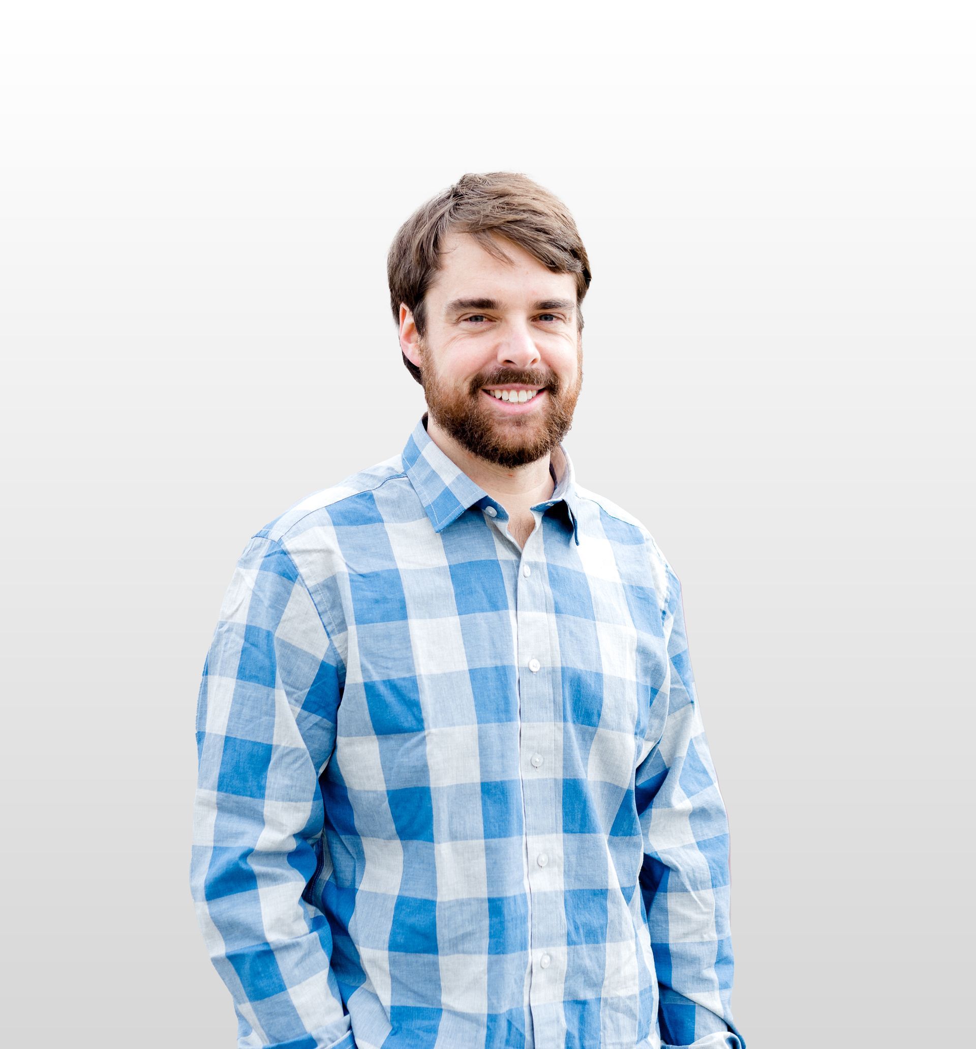 A man in a blue shirt and red tie smiles for the camera