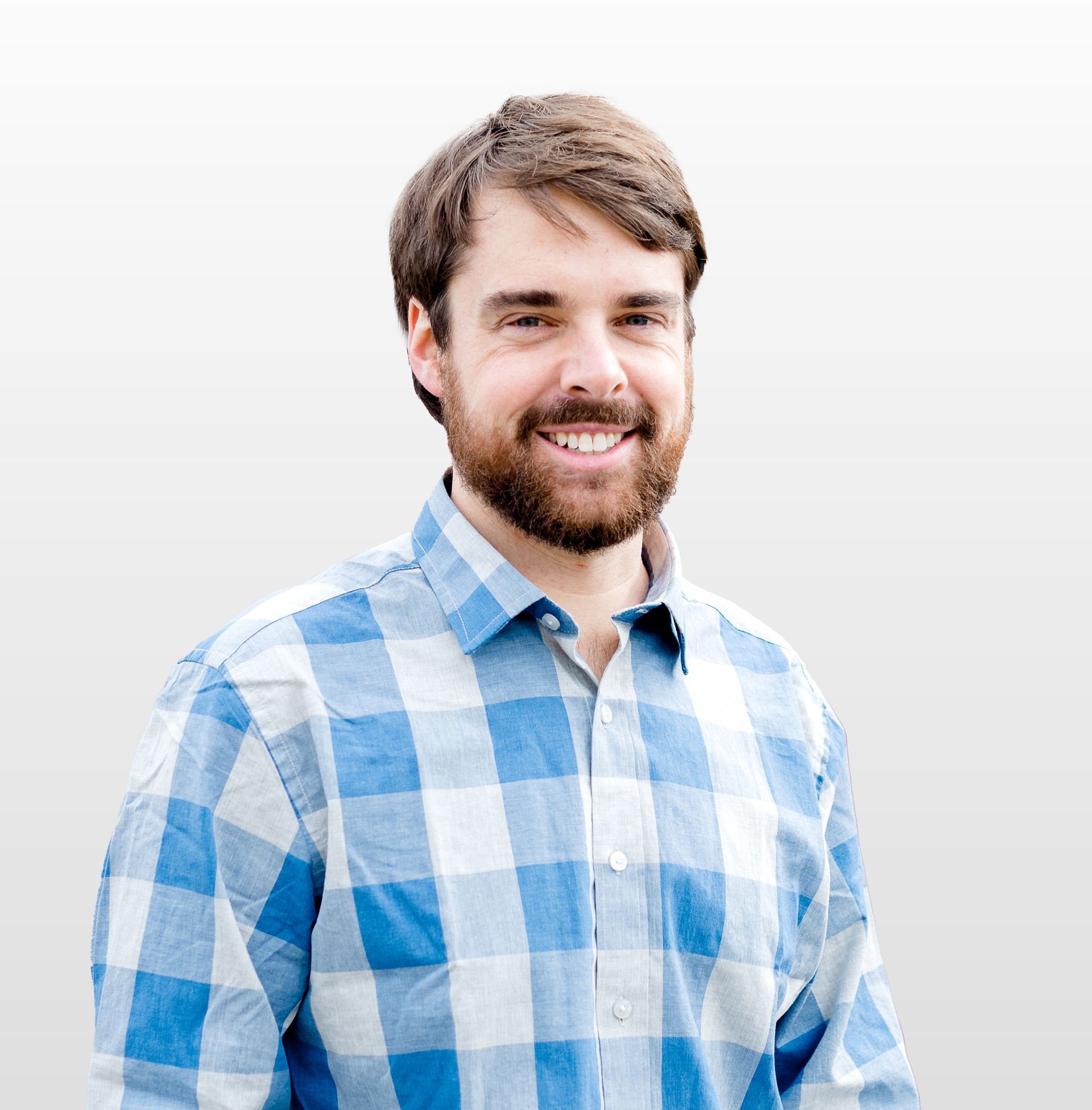 A man in a blue shirt and red tie smiles for the camera