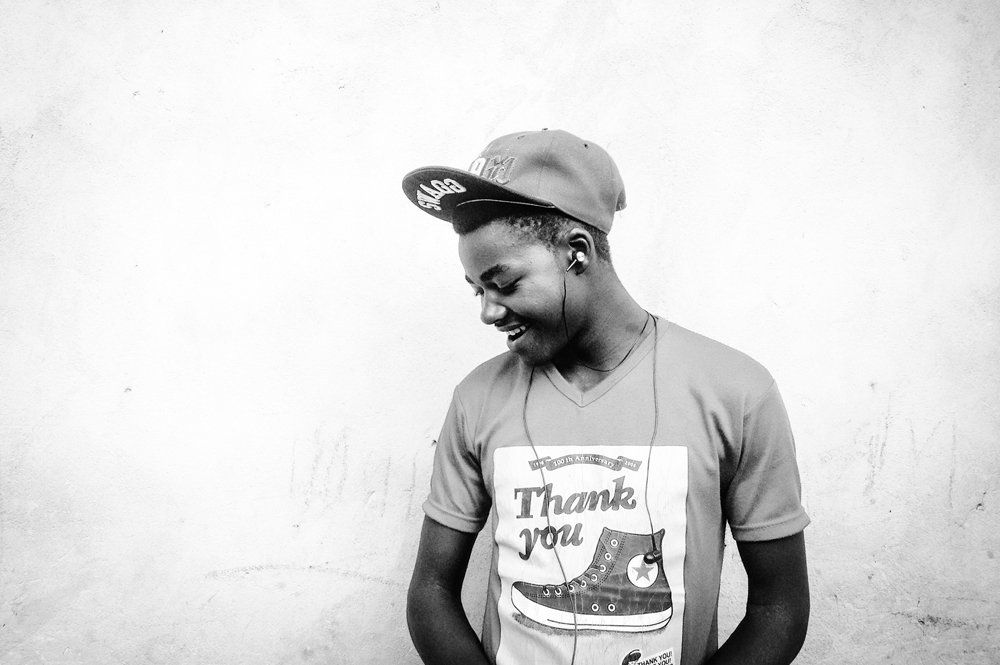 A black and white photo of a man wearing a hat and a thank you shirt.