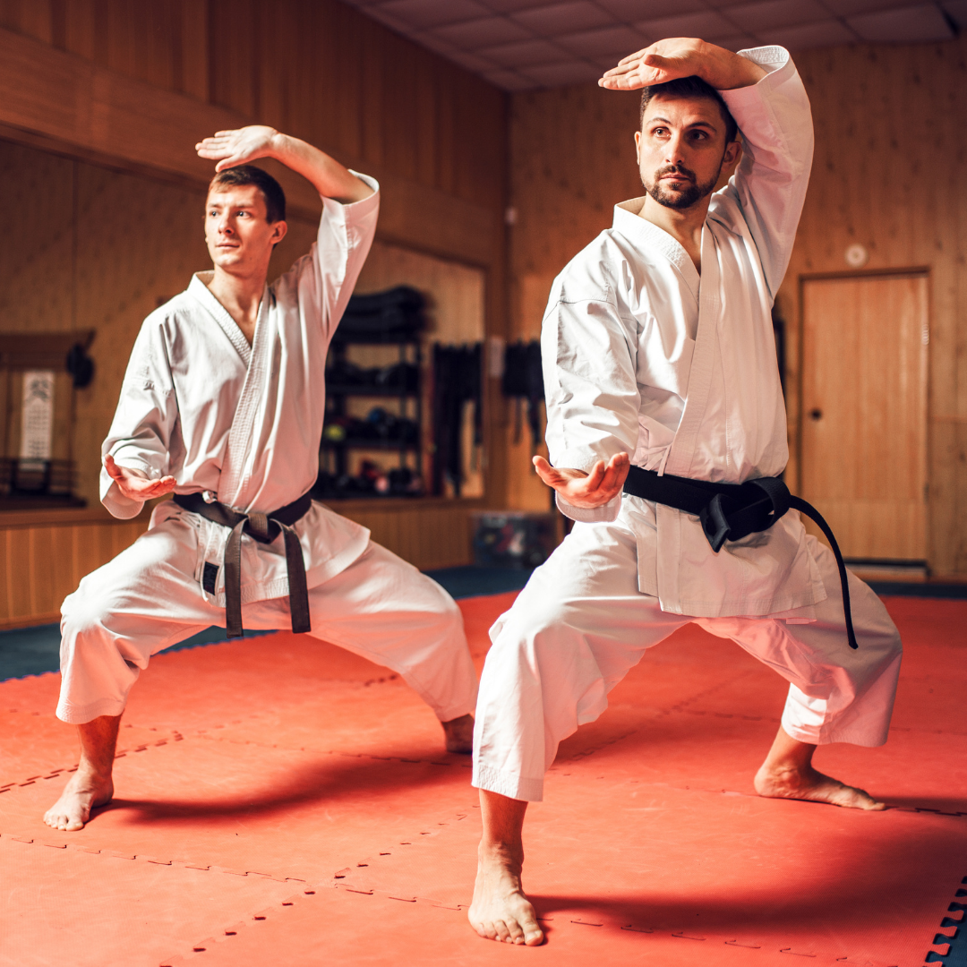 A group of men are practicing karate in a gym.