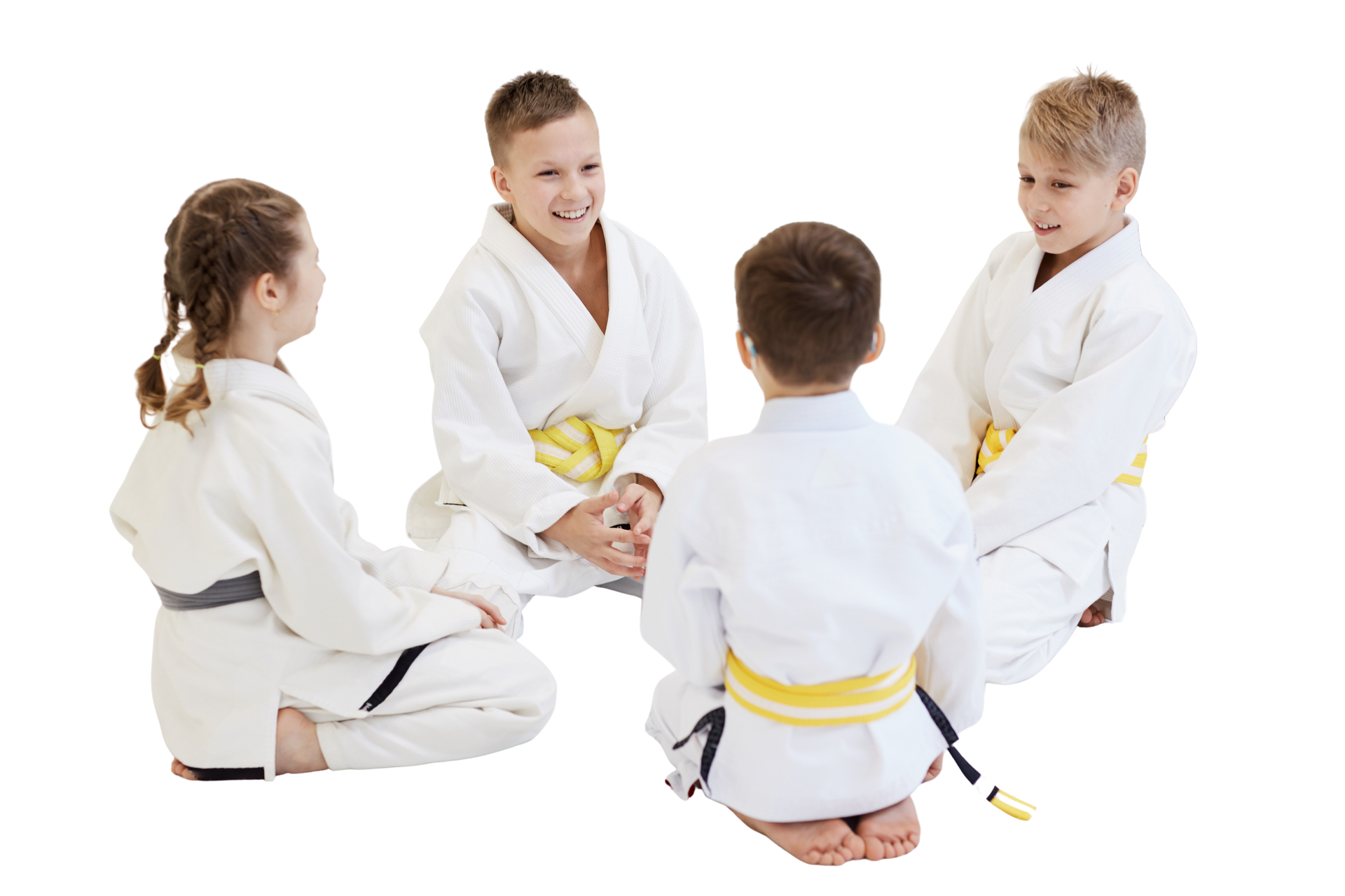 A group of kids in karate uniforms are sitting on the floor drinking water