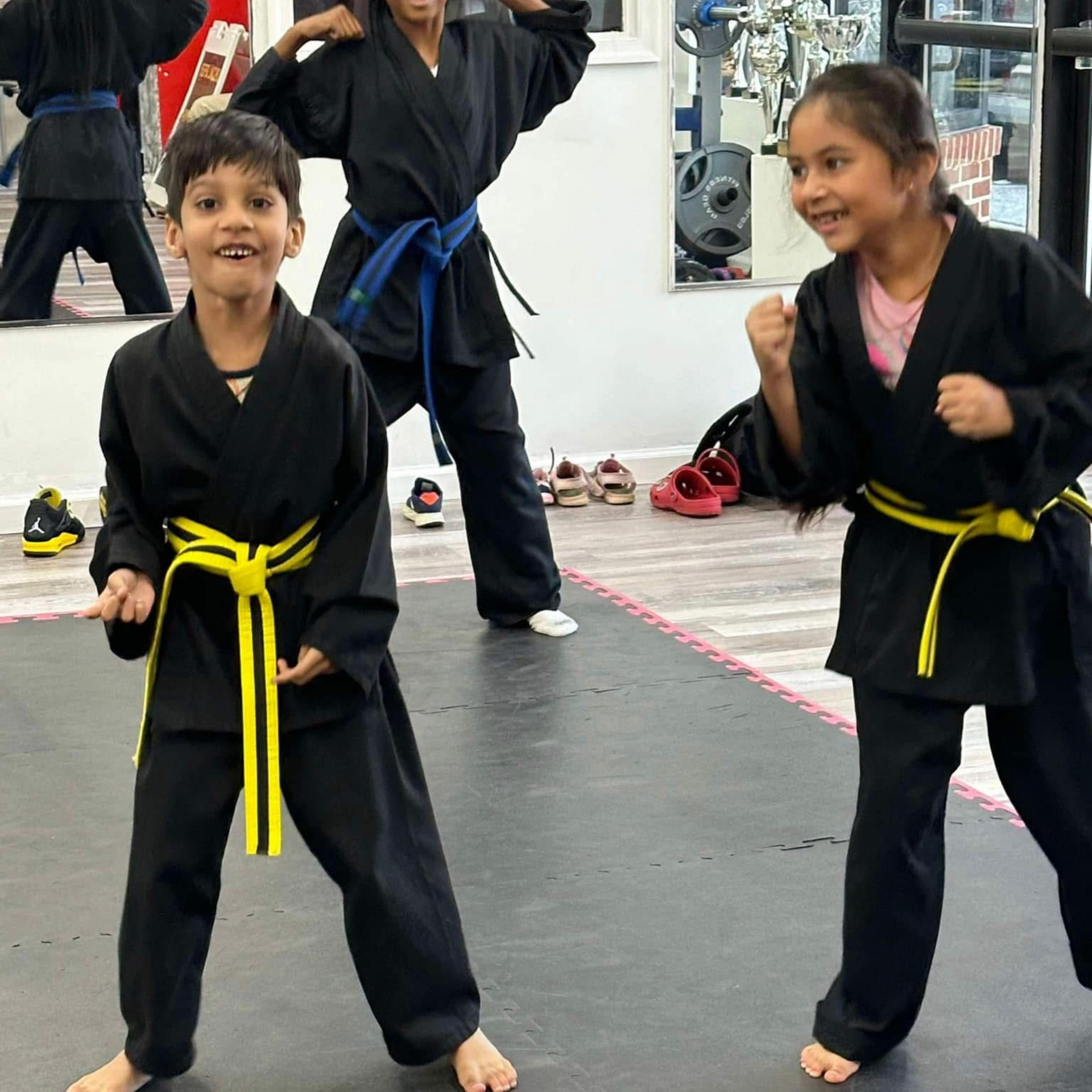 Two young boys are practicing martial arts in a dark room.