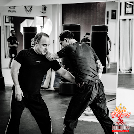 a man and a woman are wrestling on a mat in a gym .