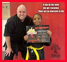 Two young boys are practicing judo in a dark room.