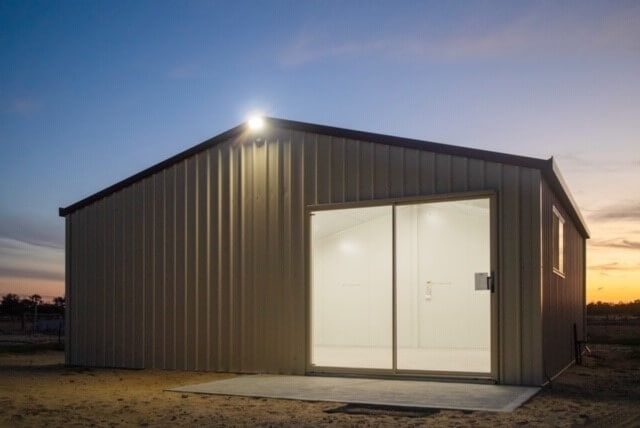 A small building with a sliding glass door and a light on the side.