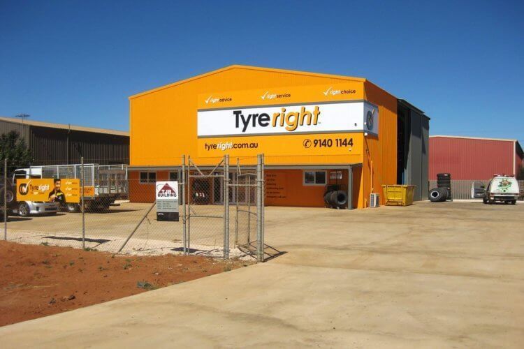 An orange building with a sign that says tyre right