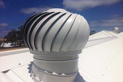 A white roof with a circular vent on top of it