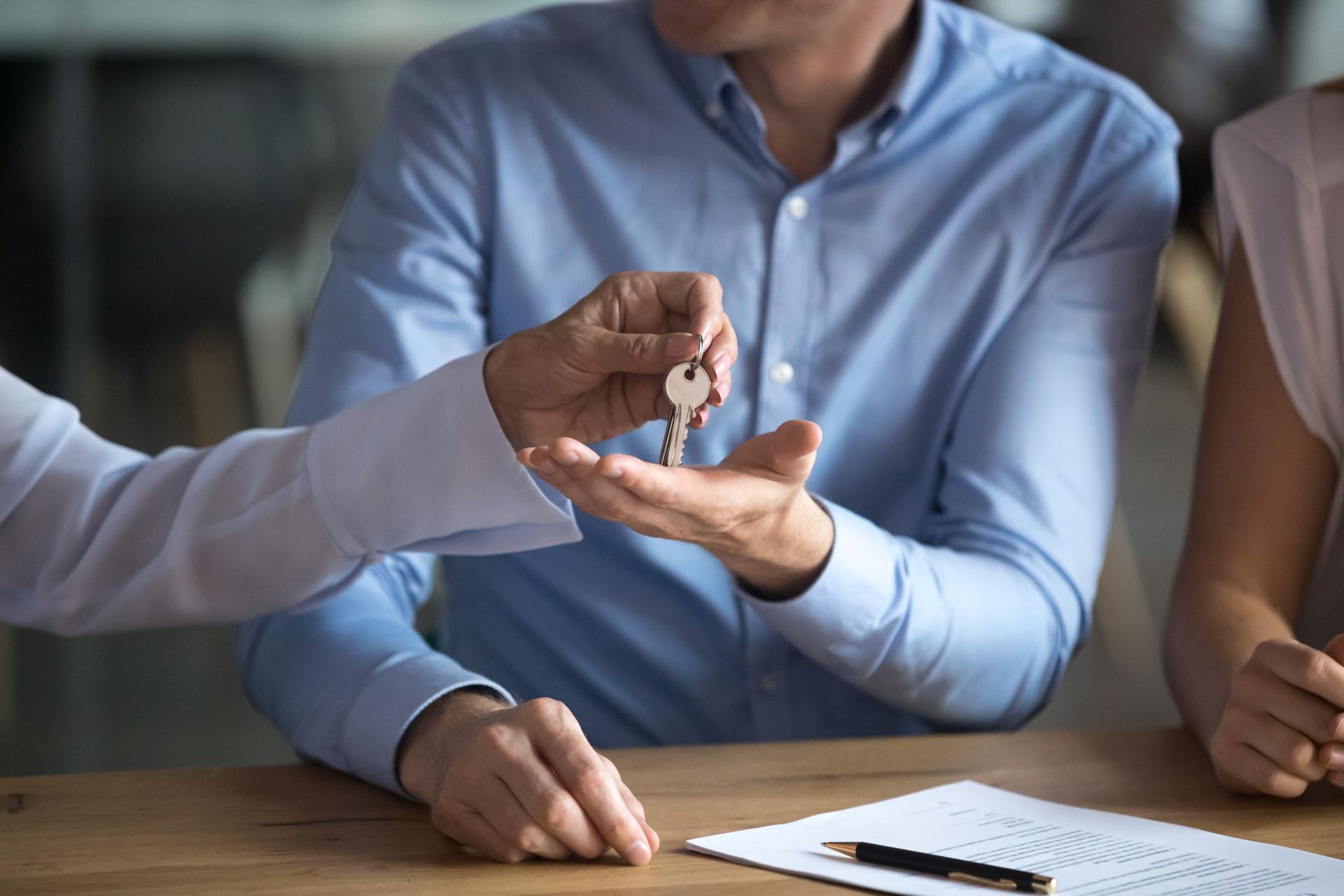 A man is giving a key to a woman.