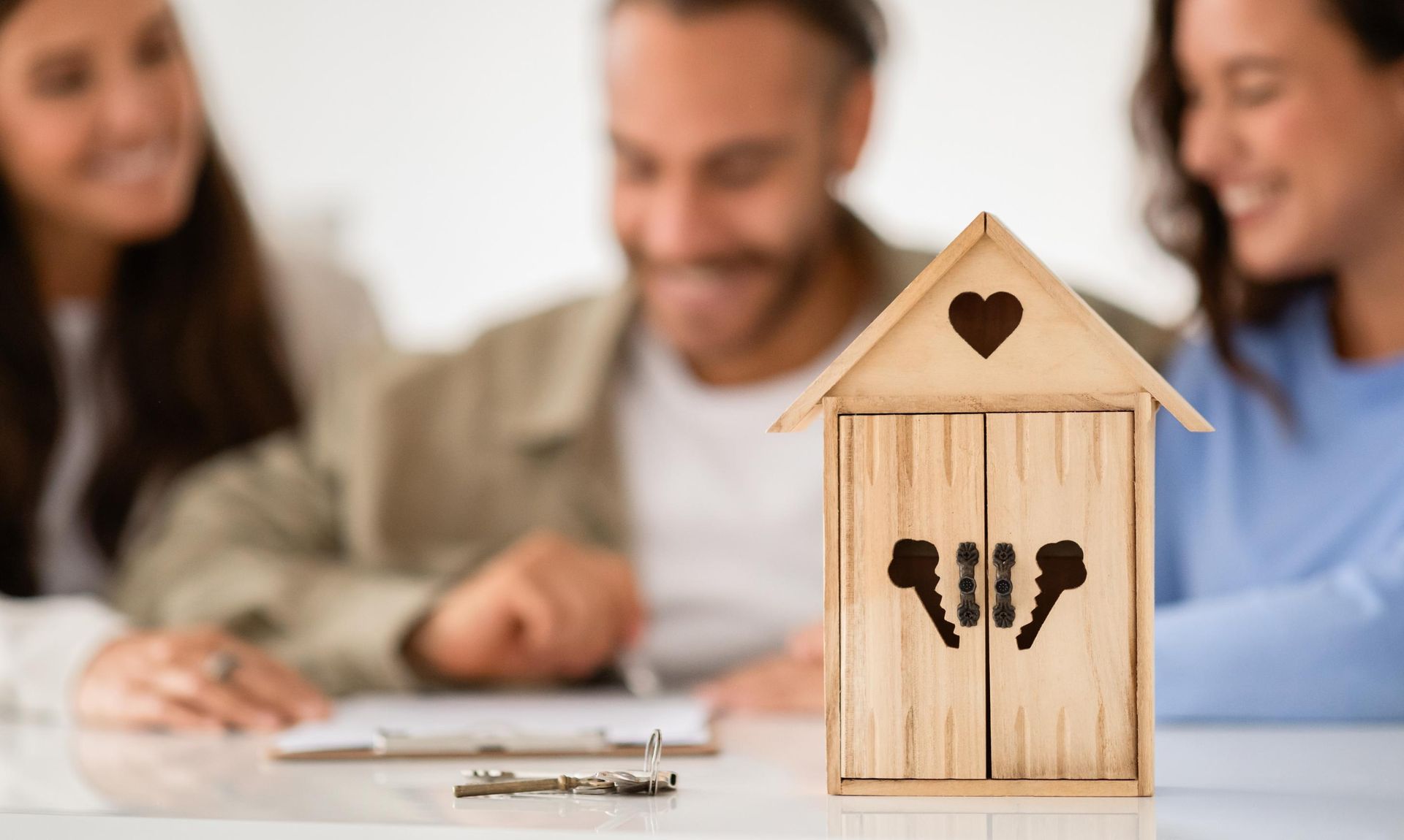 A small wooden house with a heart on the door is sitting on a table.