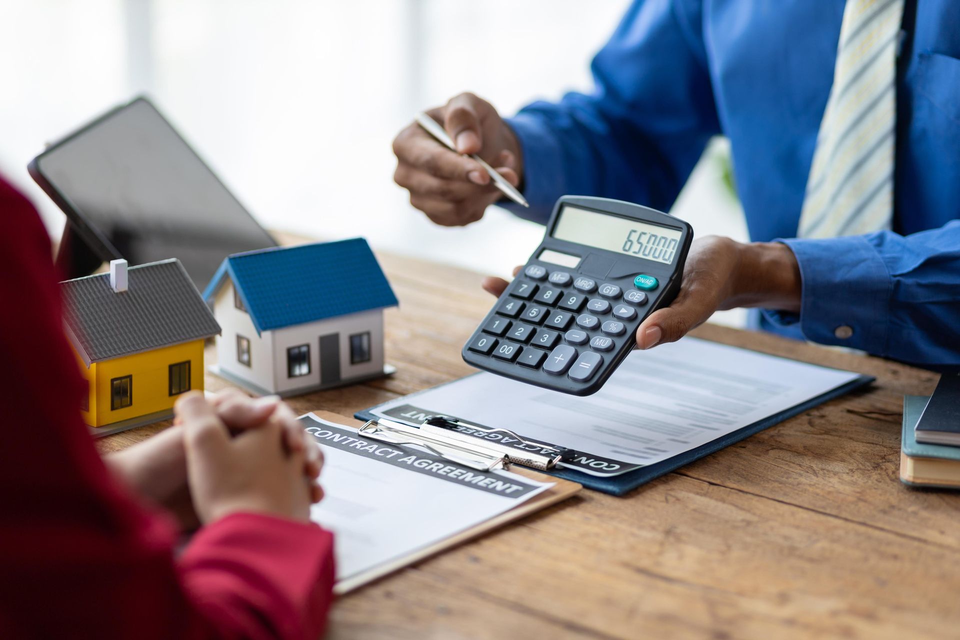 A man is holding a calculator in front of a woman.