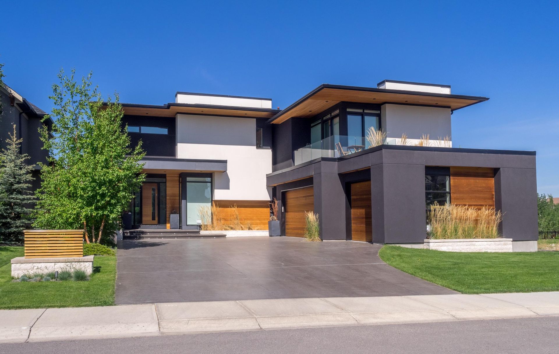 A large modern house with a driveway in front of it.