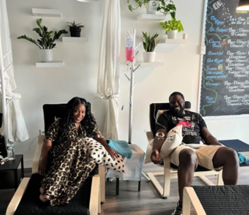 A man and a woman are sitting in chairs in front of a menu