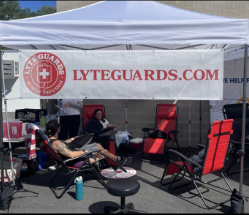 A group of people sitting under a tent that says lyteguards.com