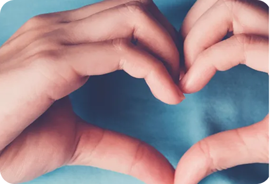 Two hands are making a heart shape with their fingers