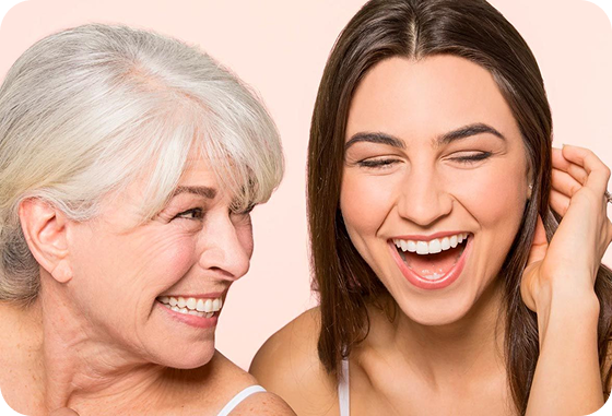An older woman and a younger woman are laughing together.