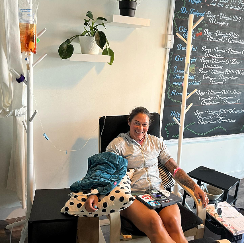 A woman is sitting in a chair in front of a chalkboard that says ' dr. ' on it