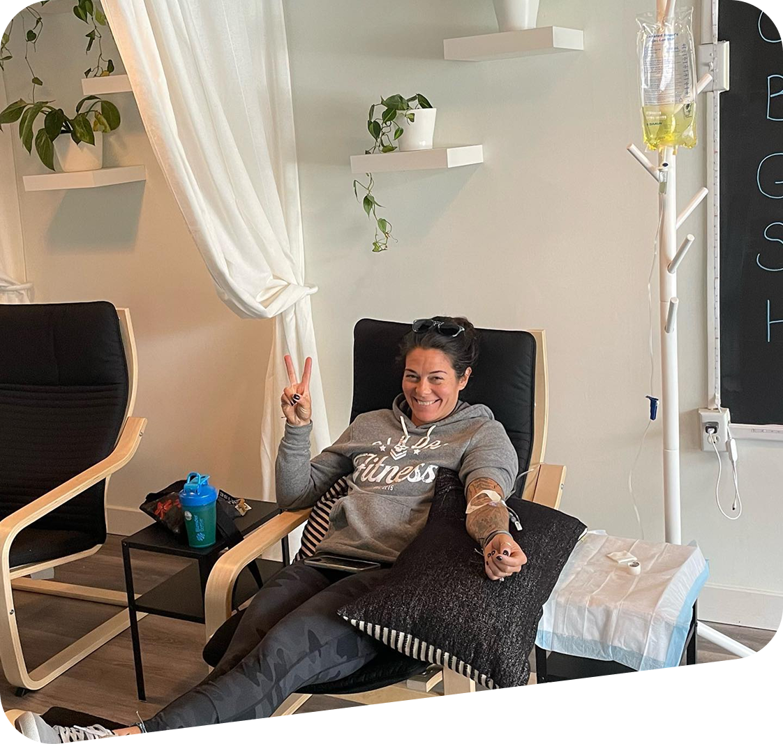 A woman is sitting in a chair with an iv in her arm.
