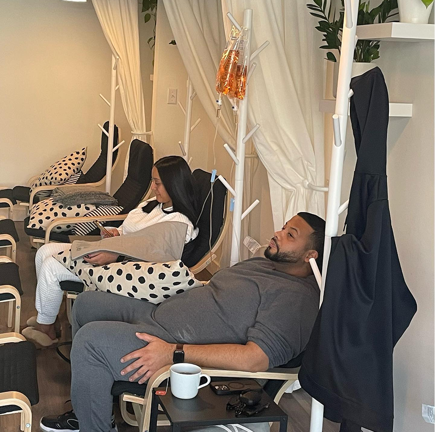A man is laying in a chair with a cup of coffee