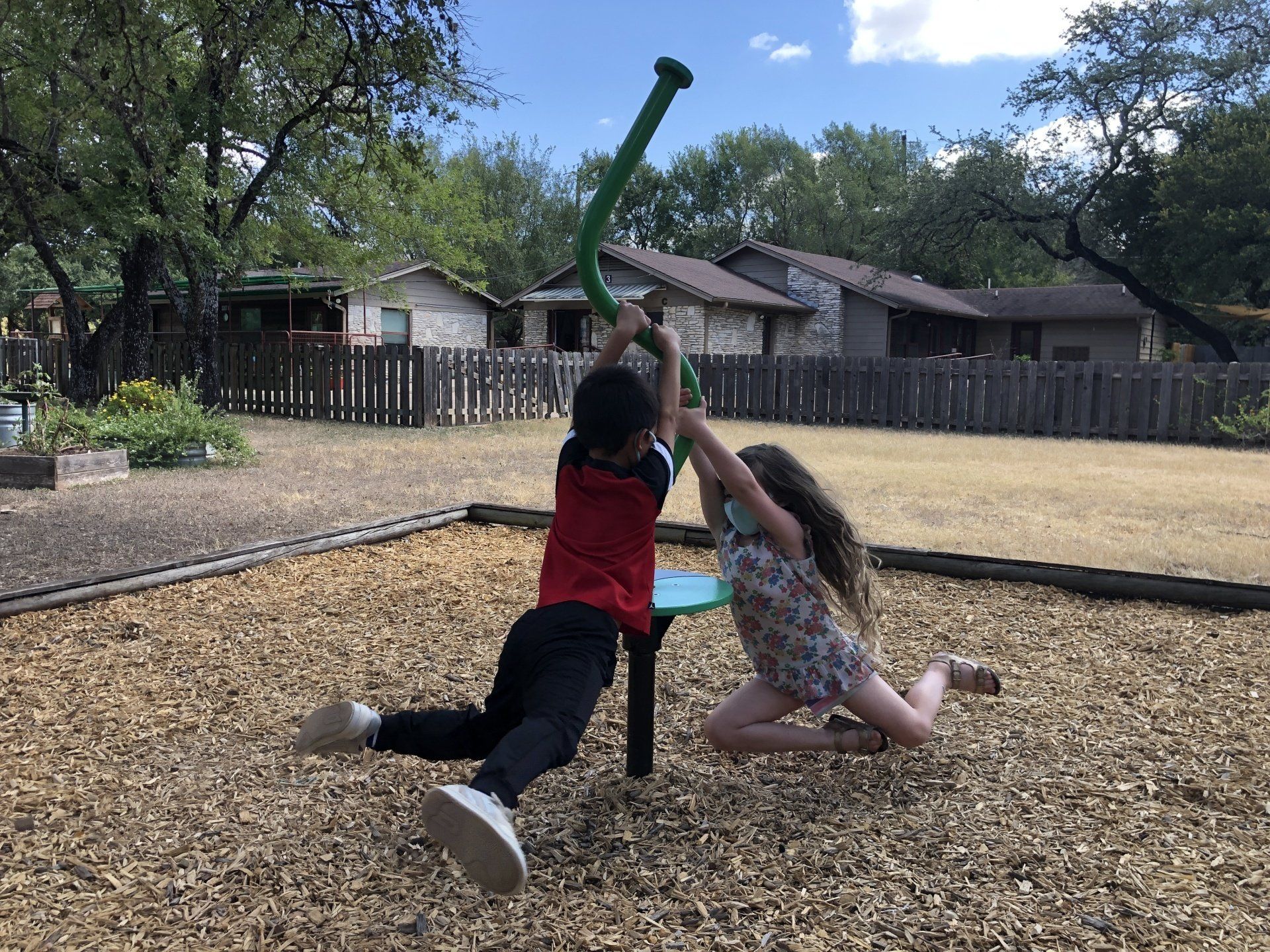 A boy and a girl are playing on a playground.