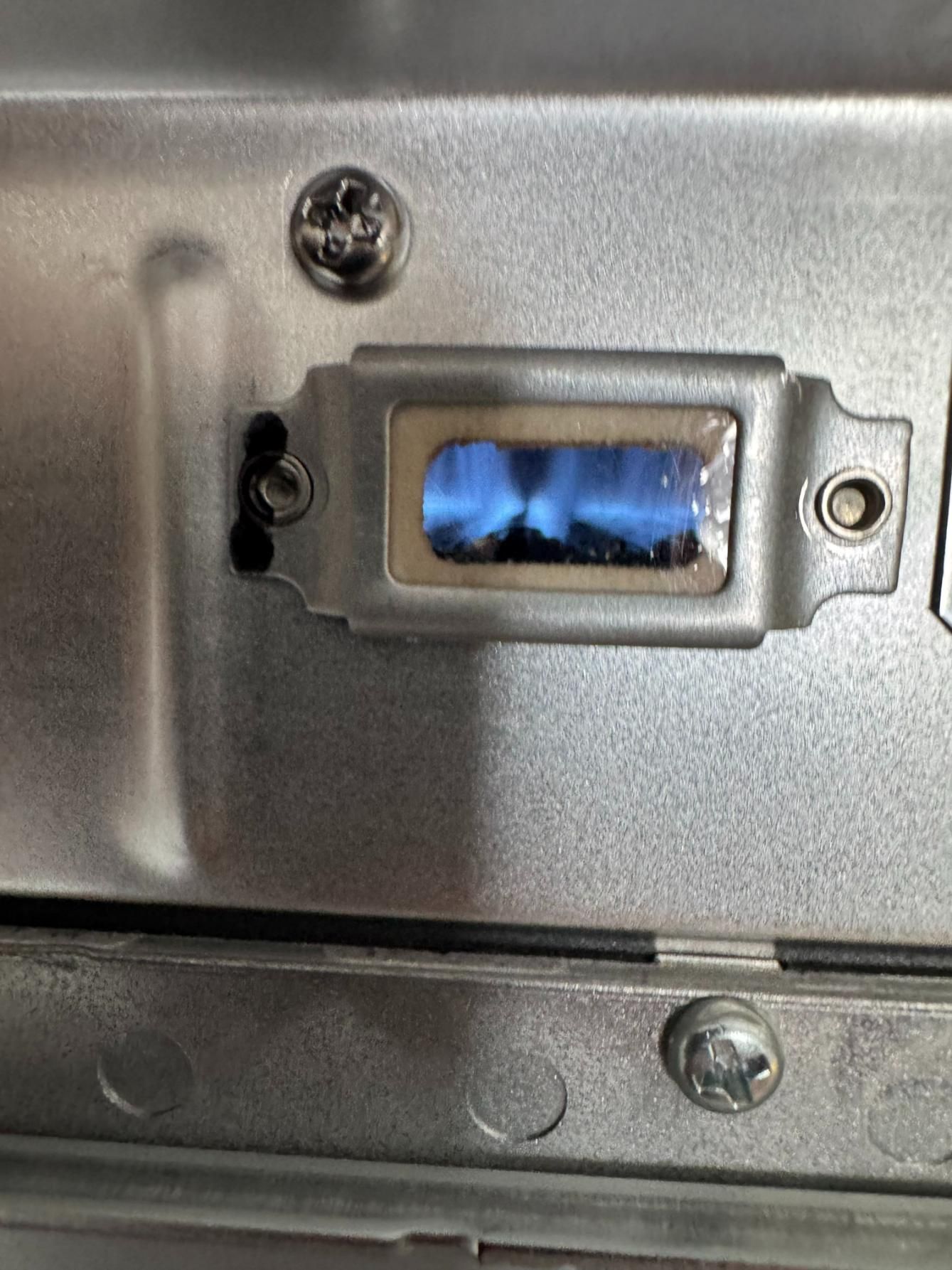Blue flame visible through a small, rectangular window in a metal appliance.