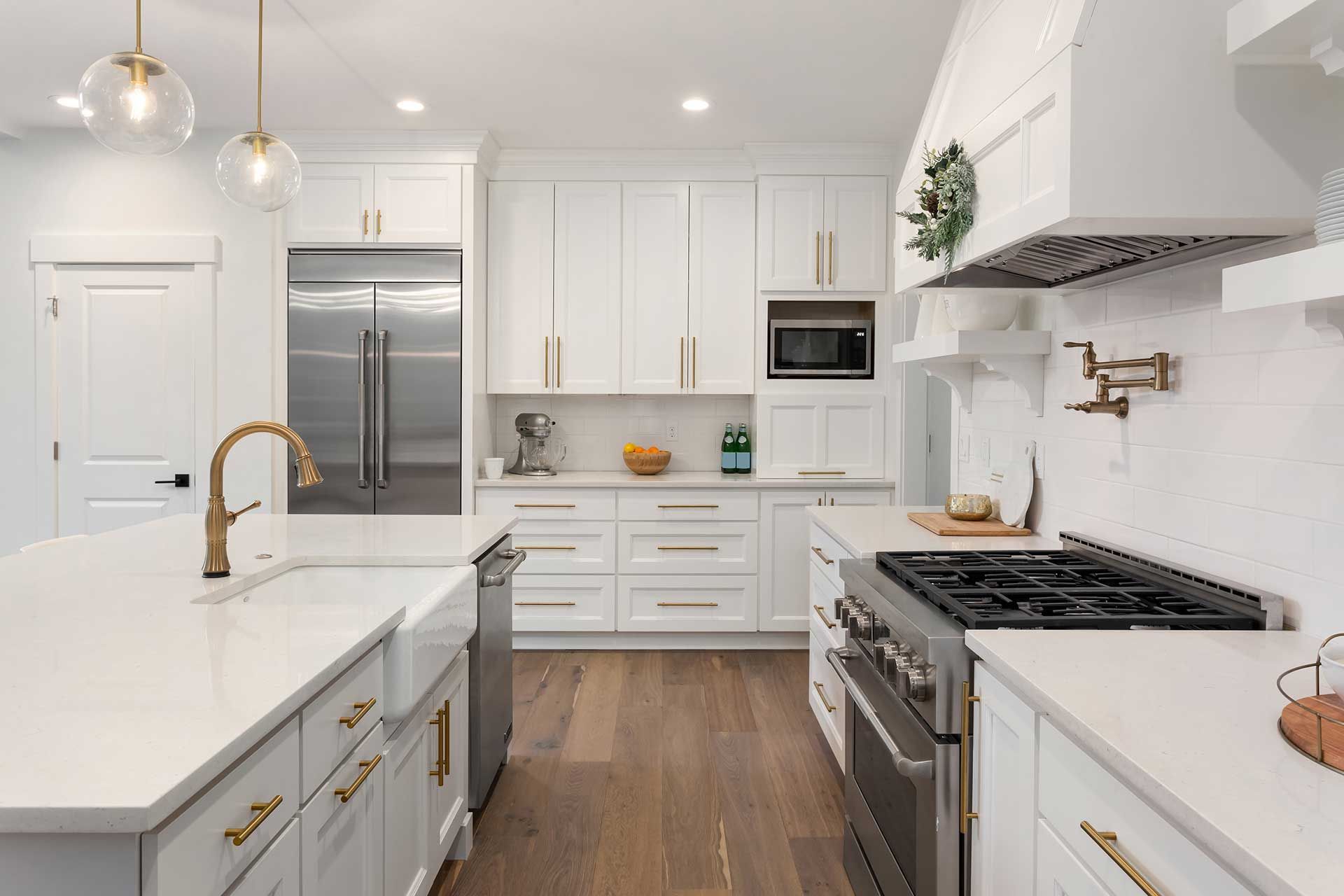 Beautiful kitchen detail in new luxury home. Features island, pendant lights, hardwood floors, and stainless steel appliances 
