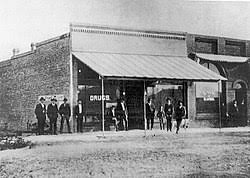 Black and white photo of a 19th-century storefront with