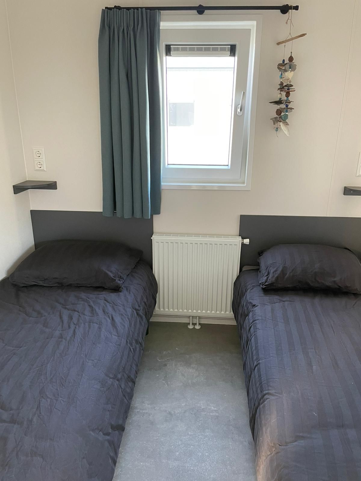 Een slaapkamer met twee bedden en een raam