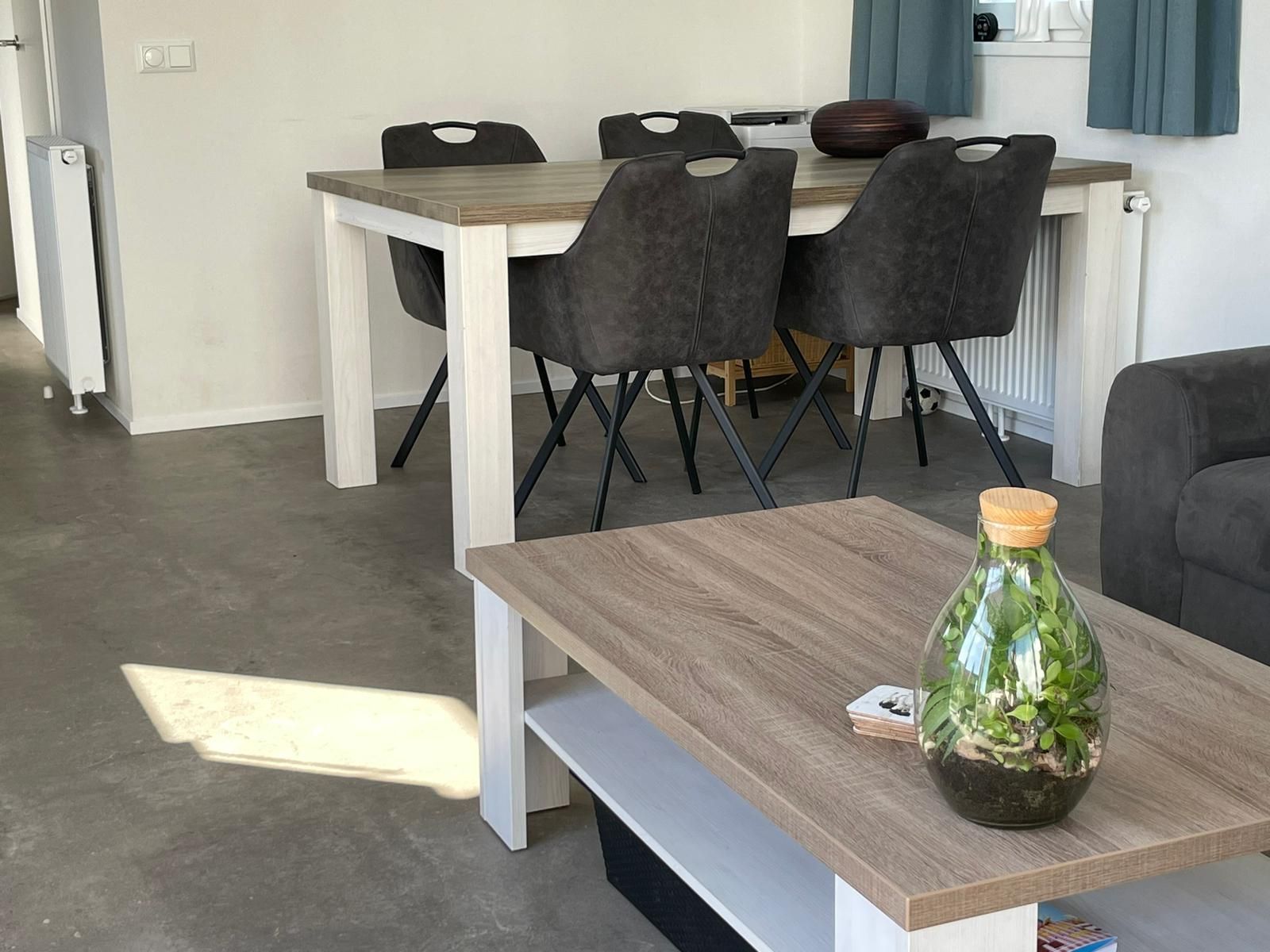 Een woonkamer met een tafel en stoelen en een salontafel