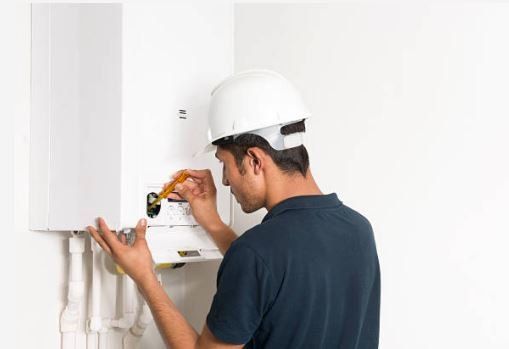 Man Fixing Heater — Rancho Cucamonga, CA — Advanced Plumbing Solutions
